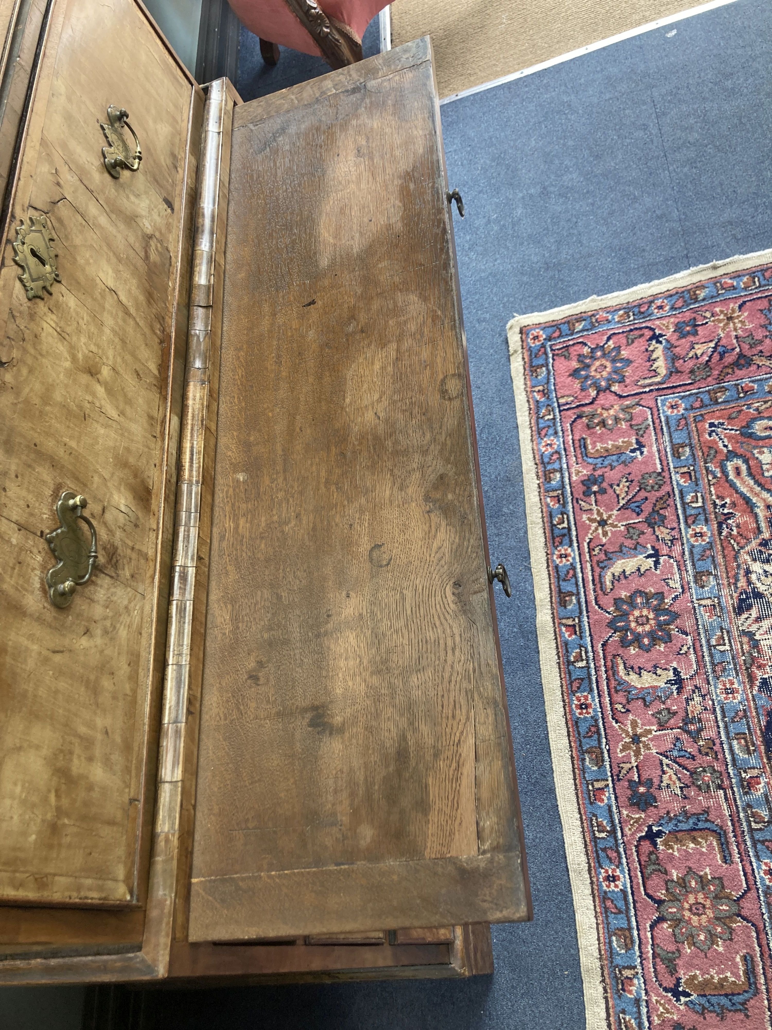 An early 18th century banded walnut tallboy, with oak sides, fitted three small and six long drawers with a brushing slide, width 105cm